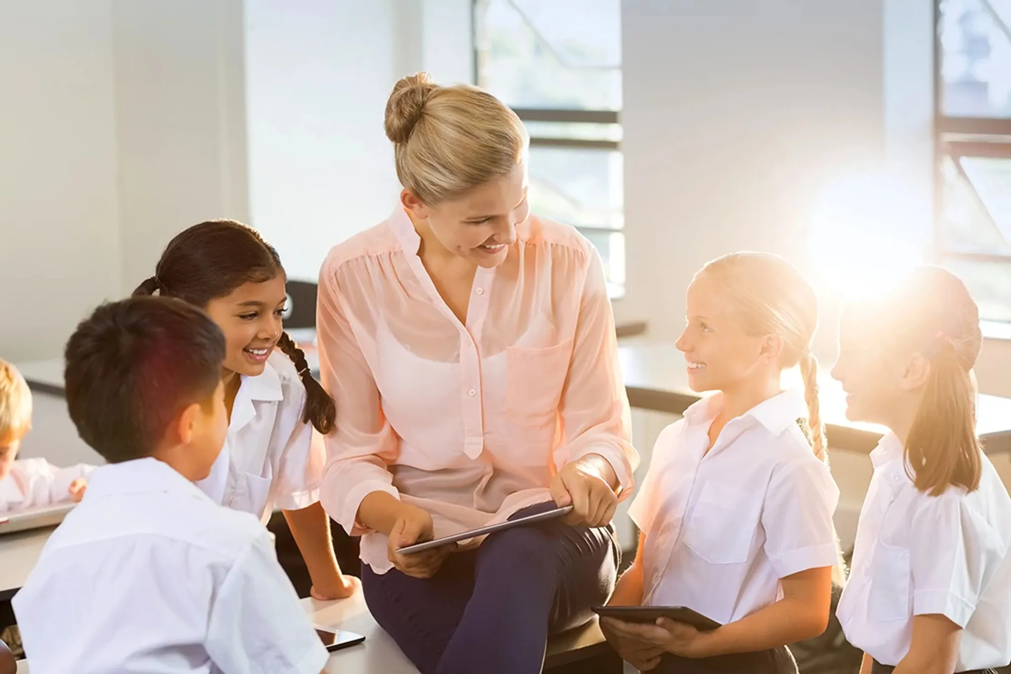 teacher with students using pcs